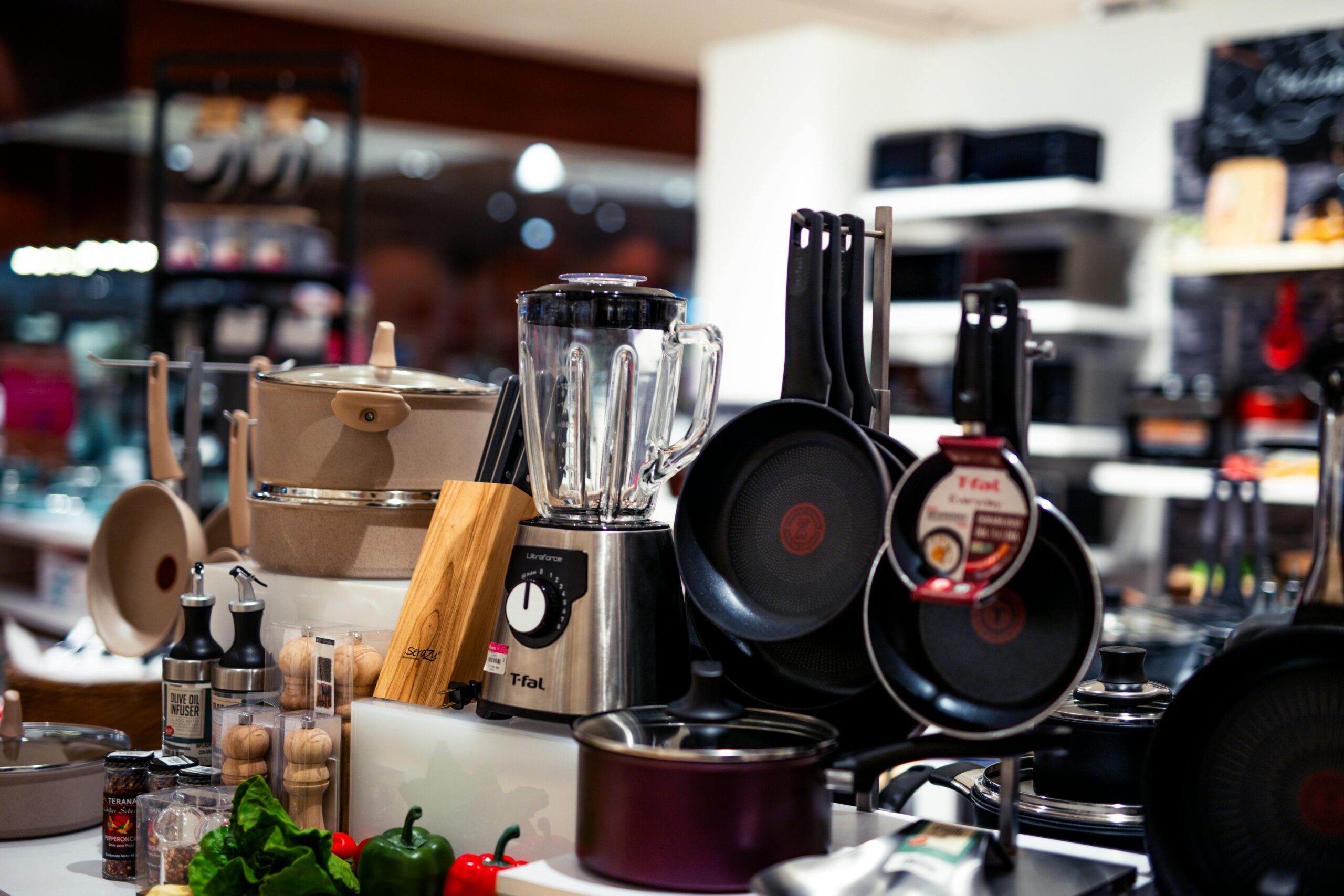 A vibrant selection of modern kitchen utensils including pans, blenders, and accessories.